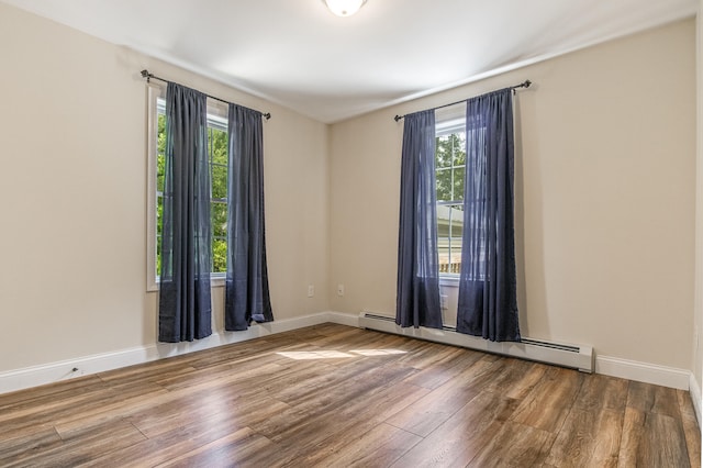 711 Newfield Rd, Shapleigh, ME 04076 - spare room featuring a baseboard heating unit, wood finished floors, healthy amount of natural light, and baseboards