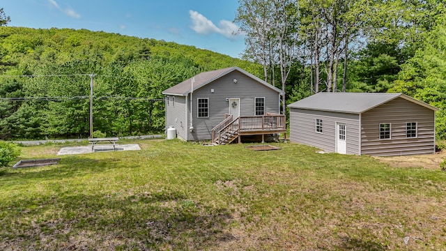 711 Newfield Rd, Shapleigh, ME 04076 - rear view of property featuring a deck, a yard, a wooded view, an outdoor structure, and stairway