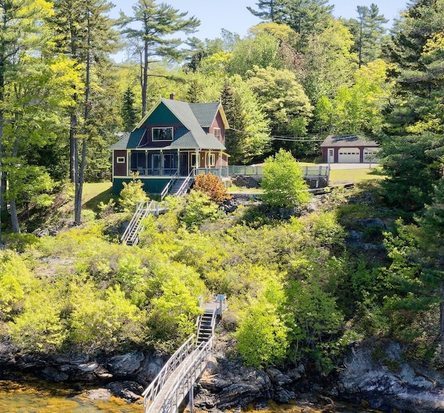 33 Houghton Pond Rd, West Bath, ME 04530 - rear view of house featuring stairway, a view of trees, and a chimney