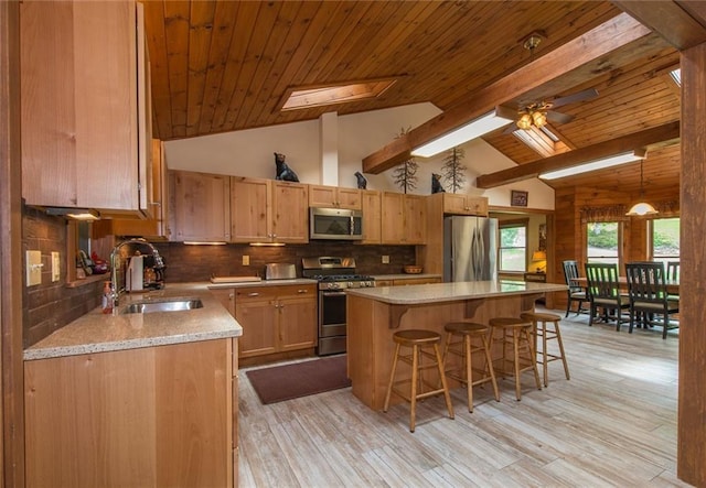 81 Bryers Cir, Boothbay, ME 04537 - kitchen featuring stainless steel appliances, a breakfast bar area, a wood ceiling with exposed beams, light countertops, and a center island