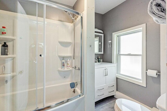 128 Benton Ave, Winslow, ME 04901 - bathroom with toilet, vanity, enclosed tub / shower combo, and wood finished floors