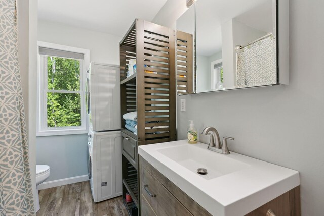 80 Hart St, Newport, ME 04953 - bathroom featuring estacked washer and dryer, vanity, wood finished floors, toilet, and baseboards