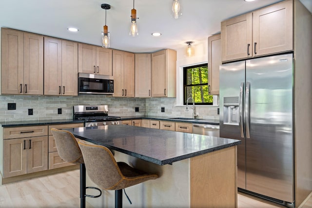 734 Main Rd, Charleston, ME 04422 - kitchen featuring stainless steel appliances, tasteful backsplash, a center island, a breakfast bar, and pendant lighting