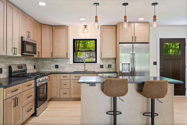 734 Main Rd, Charleston, ME 04422 - kitchen featuring appliances with stainless steel finishes, light wood-style flooring, a kitchen breakfast bar, dark countertops, and recessed lighting