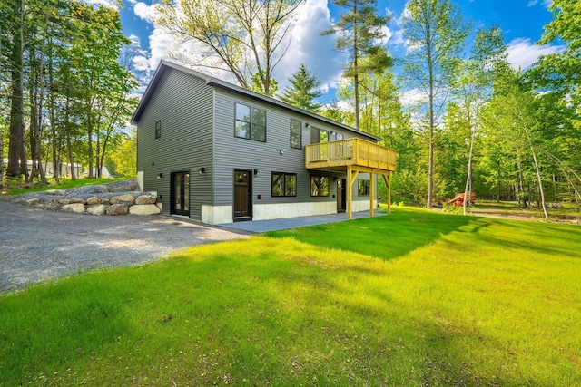 734 Main Rd, Charleston, ME 04422 - back of property featuring a yard, a wooden deck, gravel driveway, and a patio