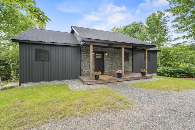 734 Main Rd, Charleston, ME 04422 - view of front of property with a porch, a shingled roof, a front lawn, and stone siding