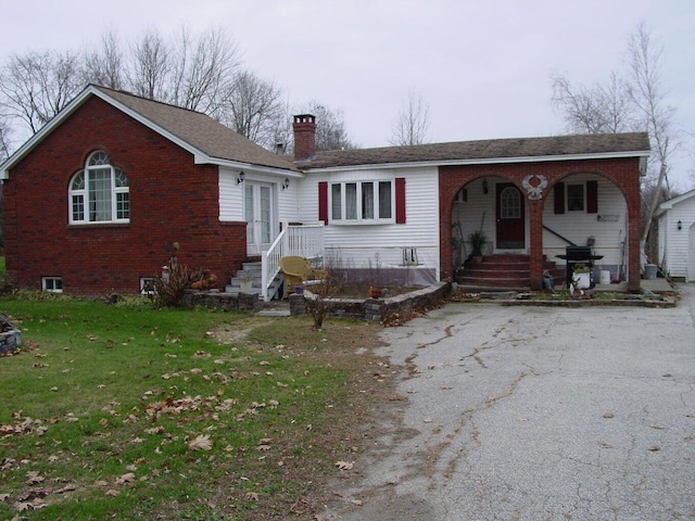 348-350 Lakeview Rd, Glenburn, ME 04401 - view of front of home featuring brick siding, a chimney, a front yard, and a porch