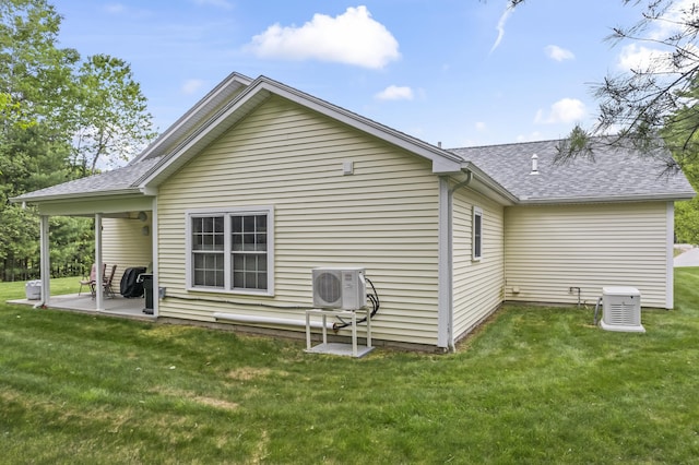 8 Macintosh Ln, Lewiston, ME 04240 - rear view of property featuring ac unit, a shingled roof, and a lawn