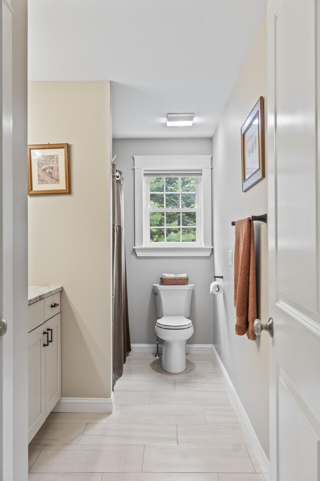 8 Macintosh Ln, Lewiston, ME 04240 - bathroom with vanity, toilet, baseboards, and curtained shower