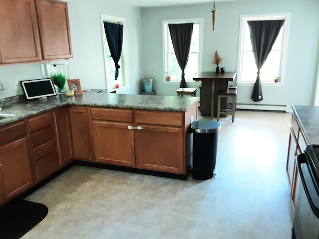 51 Bunker Hill Rd, Jefferson, ME 04348 - kitchen with a peninsula, plenty of natural light, brown cabinetry, and light floors