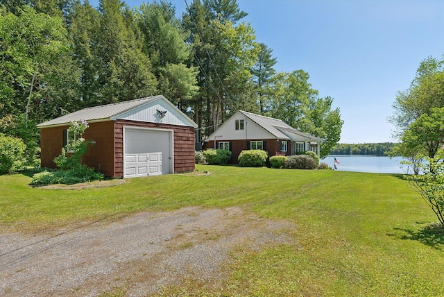 193 Park Ln, Windsor, ME 04363 - view of green lawn featuring a detached garage, a water view, an outdoor structure, and driveway