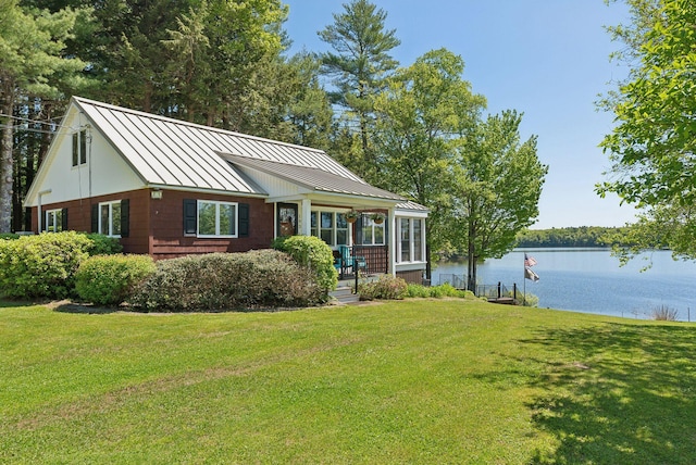 193 Park Ln, Windsor, ME 04363 - view of front of house with a standing seam roof, a water view, a front lawn, and metal roof