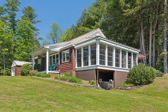 193 Park Ln, Windsor, ME 04363 - rear view of property featuring a lawn, an outdoor structure, metal roof, and a sunroom