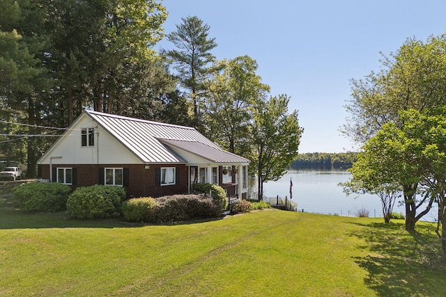 193 Park Ln, Windsor, ME 04363 - view of side of home with a standing seam roof, a lawn, a water view, and metal roof