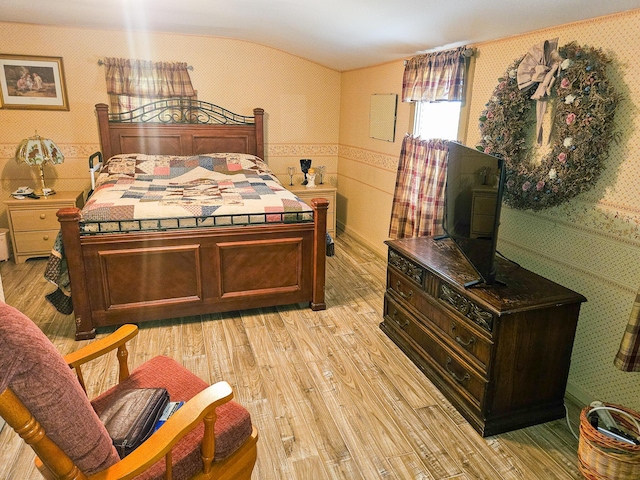 856 Weeks Mills Rd, New Sharon, ME 04955 - bedroom featuring wallpapered walls, light wood finished floors, a wainscoted wall, and lofted ceiling