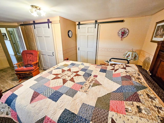 856 Weeks Mills Rd, New Sharon, ME 04955 - bedroom with a barn door and wood finished floors