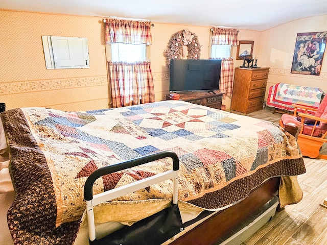 856 Weeks Mills Rd, New Sharon, ME 04955 - bedroom featuring wood finished floors, wallpapered walls, and vaulted ceiling