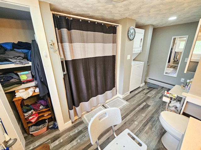 856 Weeks Mills Rd, New Sharon, ME 04955 - full bath with a baseboard heating unit, stacked washing machine and dryer, a shower with curtain, and wood finished floors