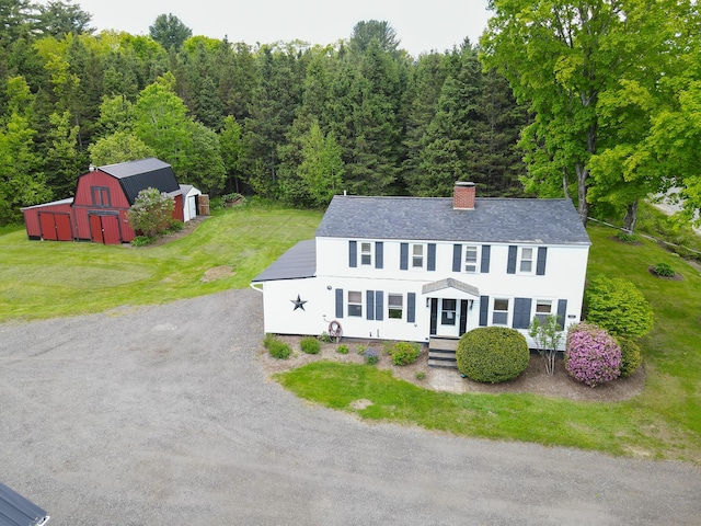 856 Weeks Mills Rd, New Sharon, ME 04955 - view of front of home featuring an outbuilding, a chimney, a view of trees, and a front lawn