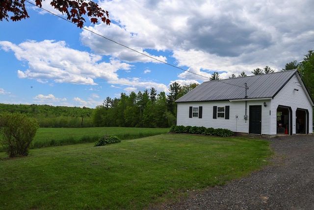856 Weeks Mills Rd, New Sharon, ME 04955 - view of front of home featuring a front lawn, a garage, metal roof, and an outdoor structure
