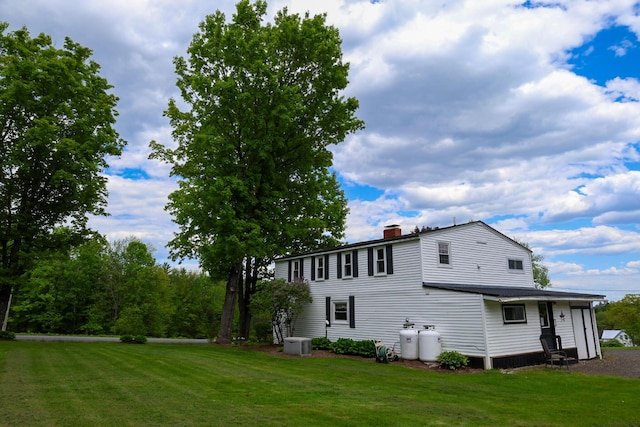 856 Weeks Mills Rd, New Sharon, ME 04955 - view of side of home with central AC unit, a chimney, and a lawn