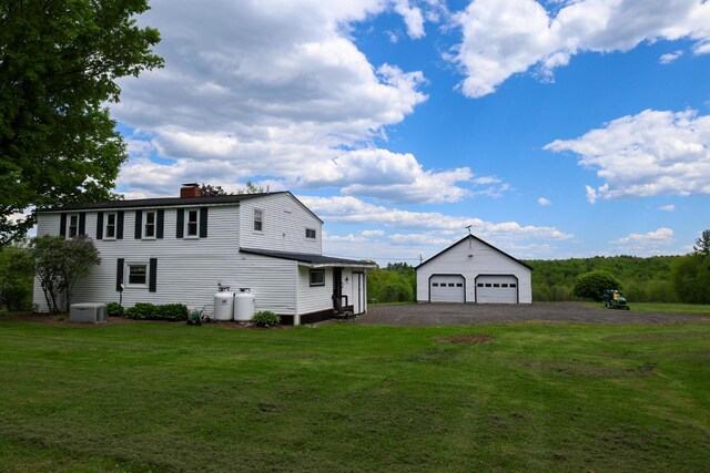 856 Weeks Mills Rd, New Sharon, ME 04955 - view of side of home with an outdoor structure, a garage, a chimney, and a yard