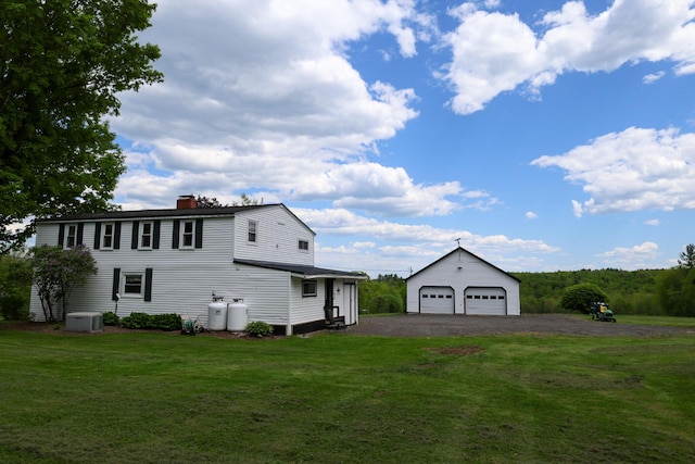 856 Weeks Mills Rd, New Sharon, ME 04955 - view of property exterior featuring a garage, an outdoor structure, cooling unit, a chimney, and a lawn