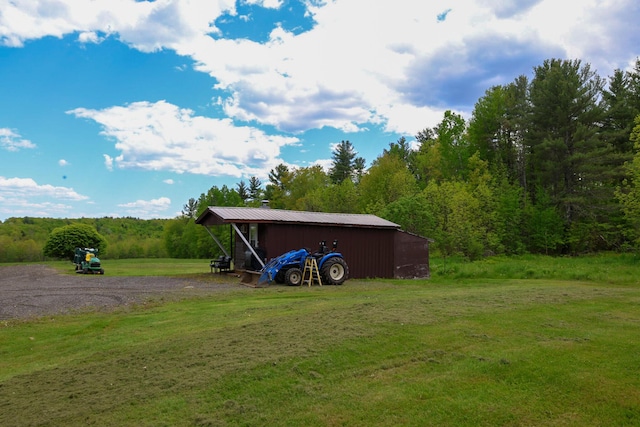 856 Weeks Mills Rd, New Sharon, ME 04955 - view of grassy yard with a pole building, an outdoor structure, and a wooded view