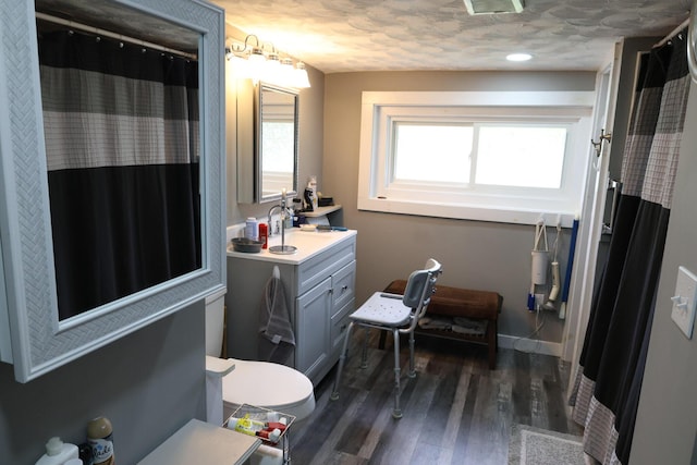 856 Weeks Mills Rd, New Sharon, ME 04955 - full bath with vanity, wood finished floors, baseboards, a shower with curtain, and toilet
