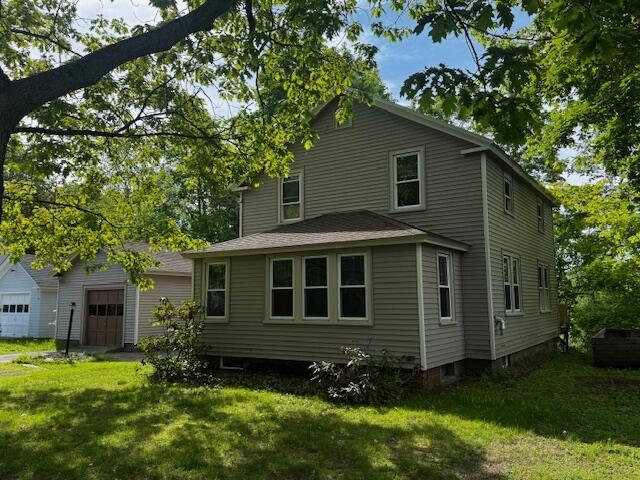 19 Prospect St, Skowhegan, ME 04976 - rear view of house with an attached garage, a lawn, and an outdoor structure