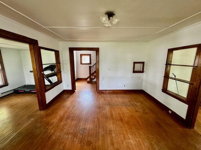 19 Prospect St, Skowhegan, ME 04976 - unfurnished room featuring hardwood / wood-style floors, stairway, plenty of natural light, and baseboards