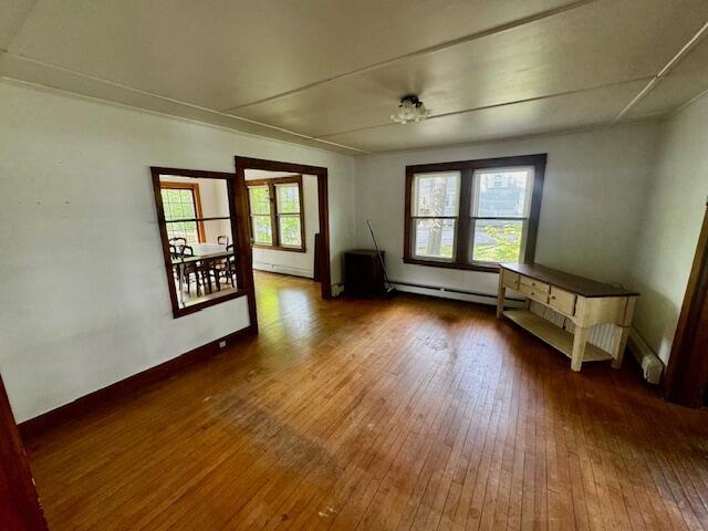 19 Prospect St, Skowhegan, ME 04976 - unfurnished living room featuring hardwood / wood-style floors and baseboard heating