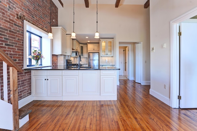 99 Silver St Unit 3-10, Portland, ME 04101 - kitchen featuring freestanding refrigerator, baseboards, glass insert cabinets, hardwood / wood-style flooring, and a high ceiling