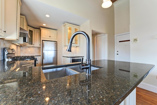 99 Silver St Unit 3-10, Portland, ME 04101 - kitchen featuring gas range, freestanding refrigerator, cream cabinetry, a sink, and glass insert cabinets
