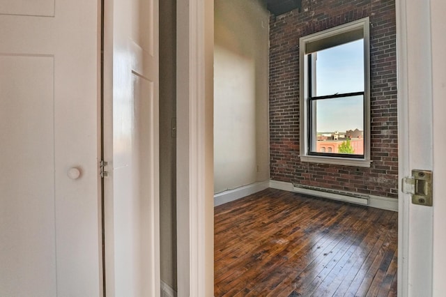 99 Silver St Unit 3-10, Portland, ME 04101 - spare room with a baseboard radiator, dark wood-type flooring, plenty of natural light, brick wall, and baseboards