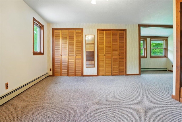 473 Davenport Hill Rd, Jay, ME 04239 - unfurnished bedroom with a baseboard heating unit, two closets, and multiple windows