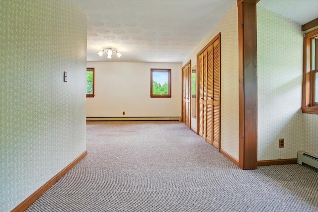 473 Davenport Hill Rd, Jay, ME 04239 - hallway featuring wallpapered walls, healthy amount of natural light, carpet, baseboards, and a baseboard heating unit
