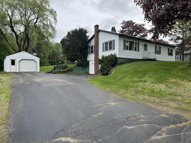 114 Summit Ave, Farmington, ME 04938 - view of front of home featuring a detached garage, a chimney, an outbuilding, a front yard, and asphalt driveway