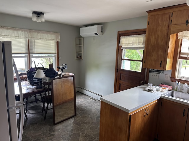 114 Summit Ave, Farmington, ME 04938 - kitchen with a wall unit AC, a sink, baseboard heating, and light countertops