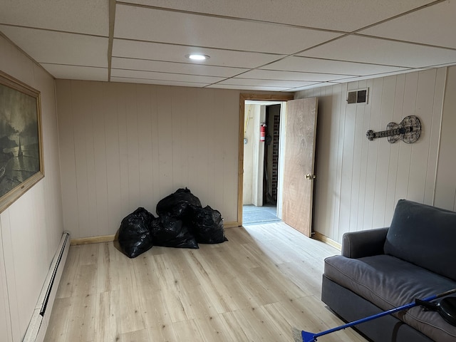 114 Summit Ave, Farmington, ME 04938 - living area with baseboard heating, wood finished floors, baseboards, and a paneled ceiling