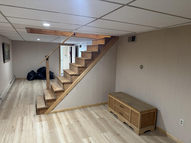 114 Summit Ave, Farmington, ME 04938 - finished below grade area with stairway, light wood-style floors, baseboards, wooden walls, and a drop ceiling