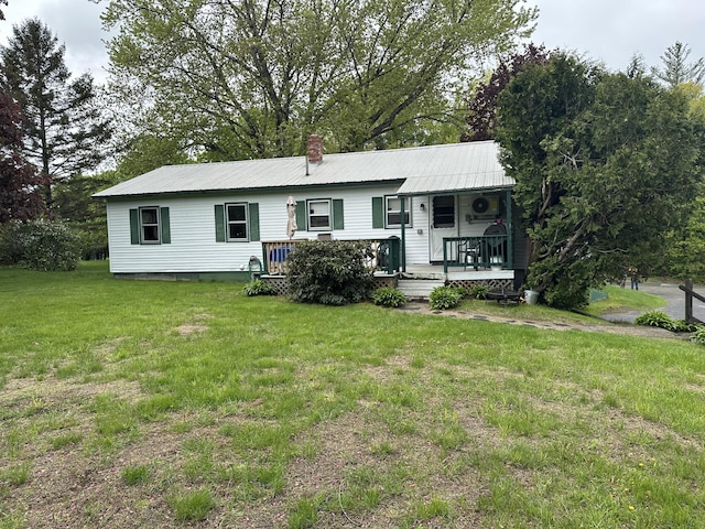 114 Summit Ave, Farmington, ME 04938 - back of house with a lawn, metal roof, covered porch, and a chimney