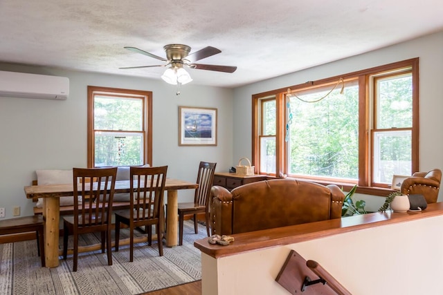 1007 Old Stage Rd, Woolwich, ME 04579 - dining room featuring a wall mounted air conditioner, healthy amount of natural light, a ceiling fan, and wood finished floors
