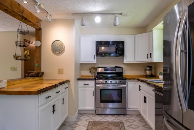 1007 Old Stage Rd, Woolwich, ME 04579 - kitchen featuring appliances with stainless steel finishes, wood counters, light floors, rail lighting, and a peninsula