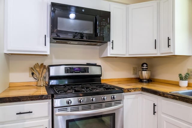 1007 Old Stage Rd, Woolwich, ME 04579 - kitchen with stainless steel range with gas stovetop, black microwave, and white cabinets