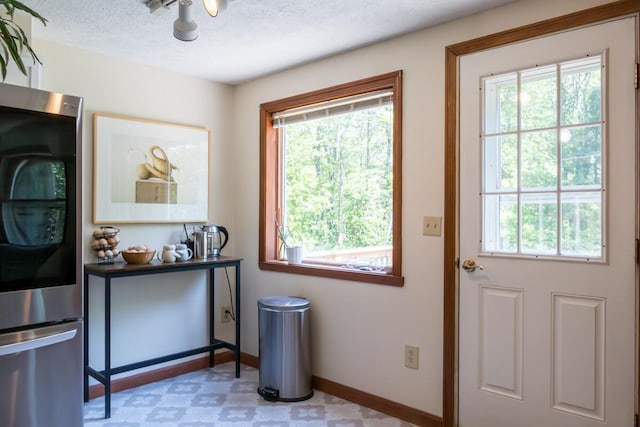 1007 Old Stage Rd, Woolwich, ME 04579 - doorway to outside with healthy amount of natural light, baseboards, light floors, and a textured ceiling