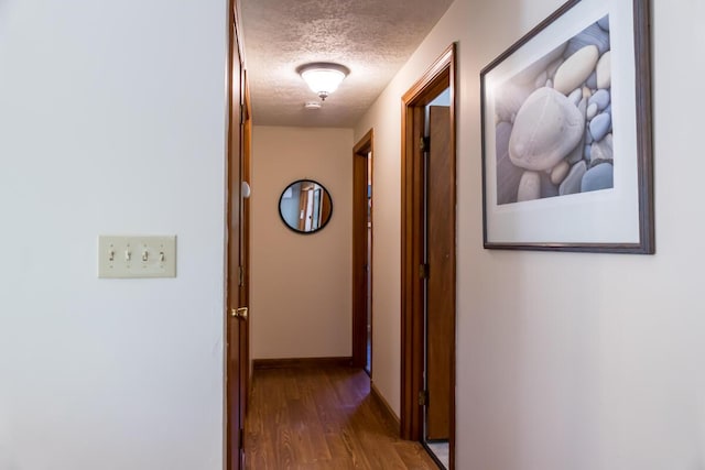 1007 Old Stage Rd, Woolwich, ME 04579 - hallway featuring a textured ceiling, wood finished floors, and baseboards