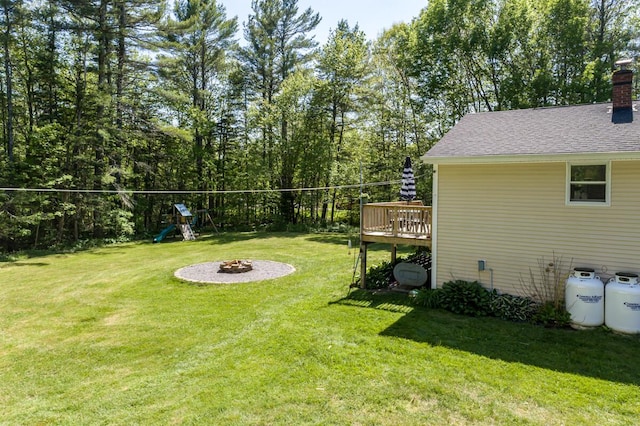 1007 Old Stage Rd, Woolwich, ME 04579 - view of green lawn featuring a fire pit, a playground, and a wooden deck