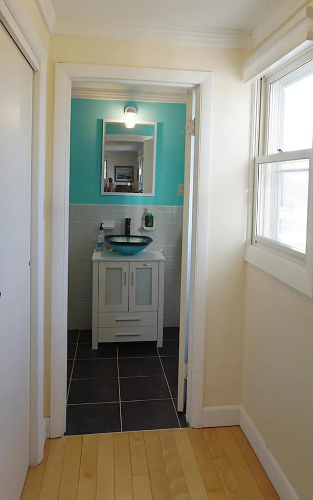 27 Misty Harbor Ln Unit 210, Cutler, ME 04626 - bathroom featuring vanity, tile walls, tile patterned floors, crown molding, and a wainscoted wall