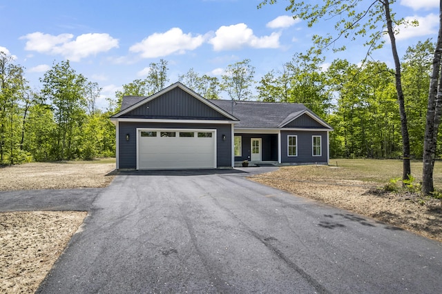 25 Sarah Vaughn Rd, Hollis, ME 04042 - ranch-style home with driveway, an attached garage, and a shingled roof